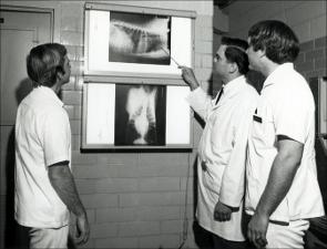 Three men study an Xray   (click for a larger preview)